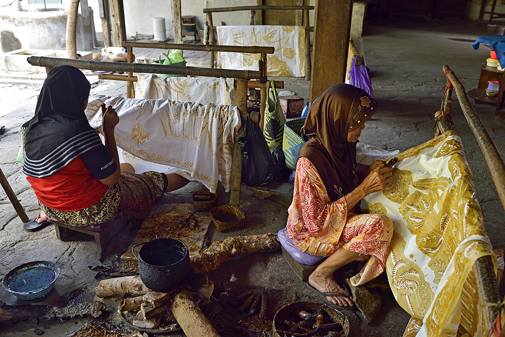 women using a pen-like tool, called 'canting', to apply liquid hot wax to create directly pattern on the fabric without preliminary drawing, Nyah Kiok batik house, craft production by seven women for over 30 years, Lasem, Java island, Indonesia, Southeast