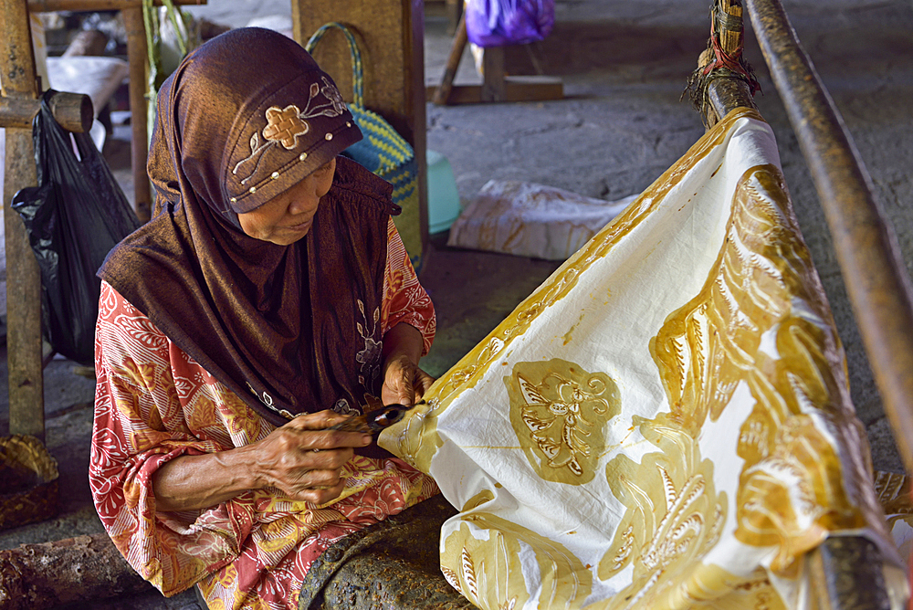 women using a pen-like tool, called 'canting', to apply liquid hot wax to create directly pattern on the fabric without preliminary drawing, Nyah Kiok batik house, craft production by seven women for over 30 years, Lasem, Java island, Indonesia, Southeast