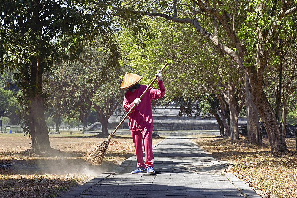 Sweeper in front of Sewu Temple Compound, 8th century Buddhist temple located at the north of Prambanan Temple Compounds, region of Yogyakarta, Java island, Indonesia, Southeast Asia, Asia