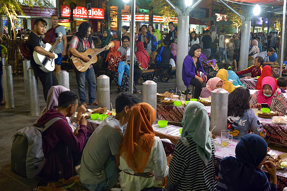 Open-air street side restaurant (lesehan) by night on Malioboro Street, major shopping street in Yogyakarta, Java island, Indonesia, Southeast Asia, Asia