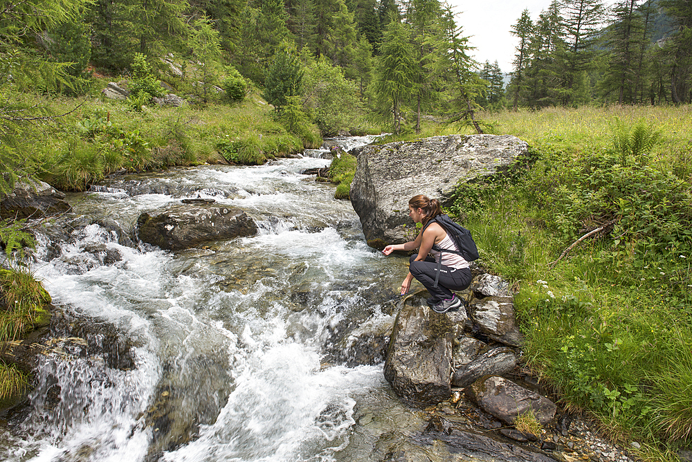 young woman by the torrent, Riva Valley (Italian: Val di Riva, German: Reintal), adjacent to Ahrntal (Valle Aurina), Trentino-Alto Adige, Sudtyrol, South Tyrol, Italy, South-central Europe