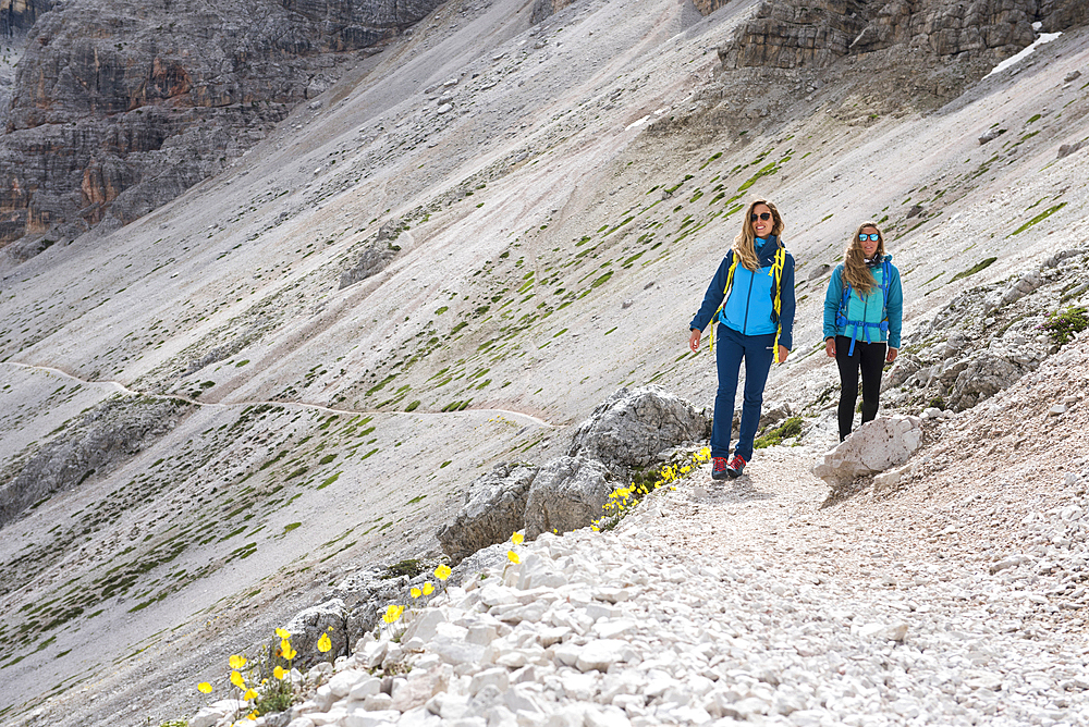 Two hikers crossing a scree, Three Peaks Nature Park, Dolomites, South Tyrol (Alto Adige), Italy