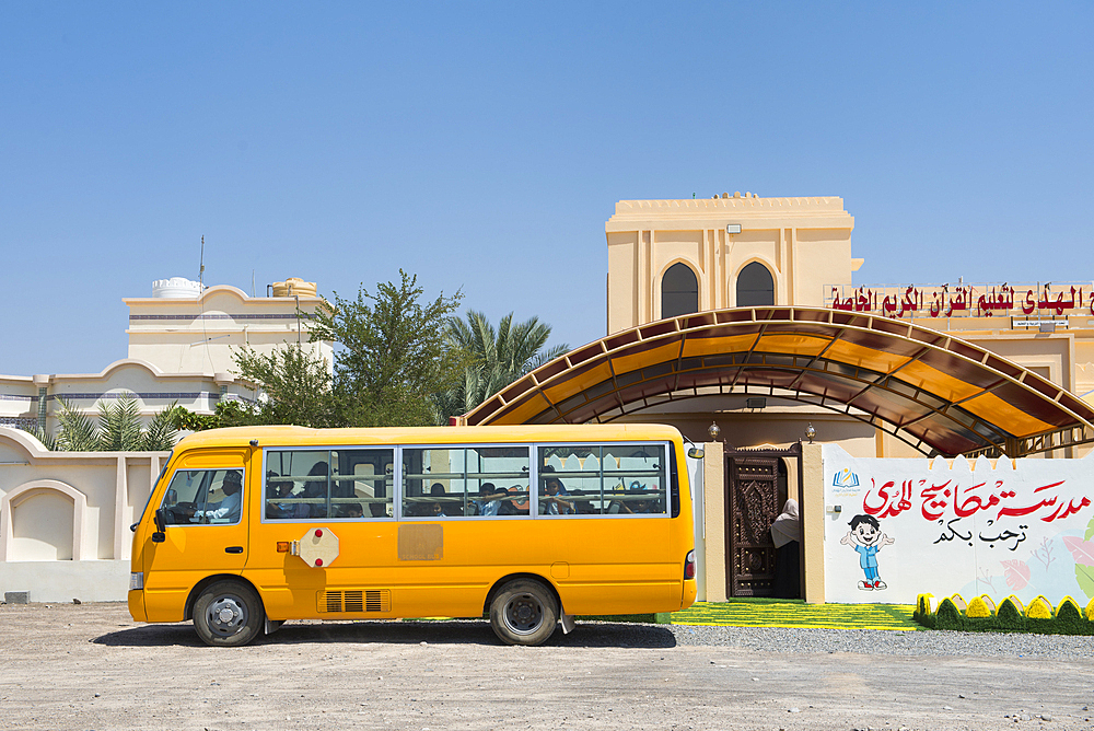 School bus in front of a school, Al Sharqiyah region, Sultanate of Oman, Arabian Peninsula, Middle East