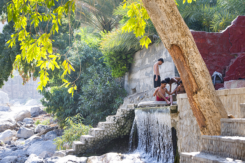 Young men bathing at Al Thowarah hot spring also called the Nakhal Hot springs, Sultanate of Oman, Arabian Peninsula, Middle East