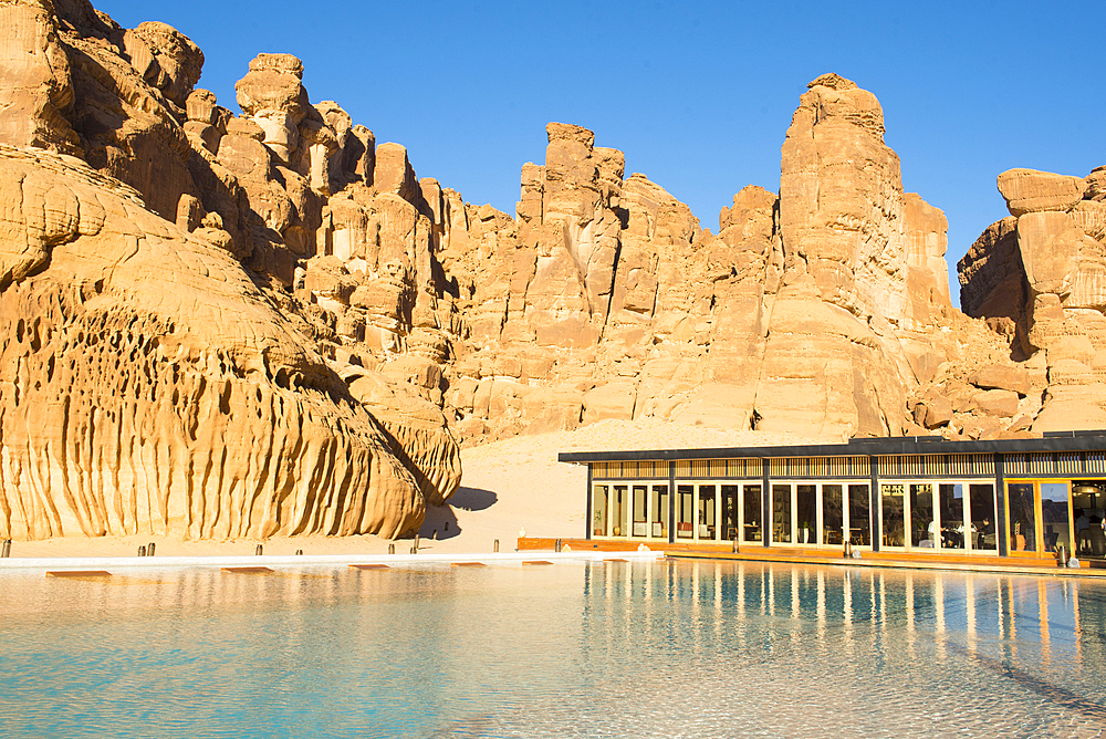 Swimming pool, surrended by magnificent sandstone rock structures, of Our Habitas AlUla, a sustainable desert luxury resort nestled within an ancient oasis in the desert canyons of the Ashar Valley, Medina Province, Saudi Arabia, Middle East