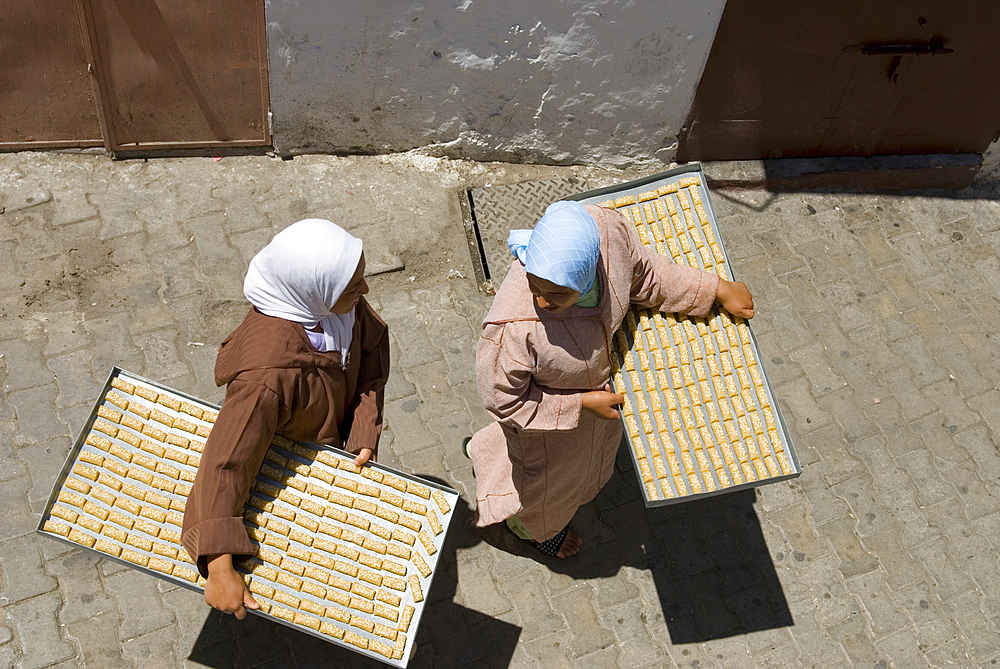 Women on the way to the commonplace oven with cakes on tray, Medina,Tangier,Morocco