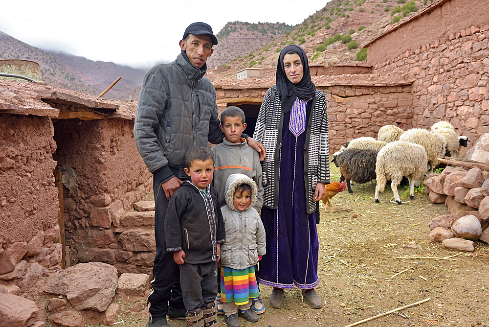 Mother and father and their children in the yard of the house they live in exchange for their work, village of Tighza, Ounila River valley, Ouarzazate Province, region of Draa-Tafilalet, Morocco, North West Africa