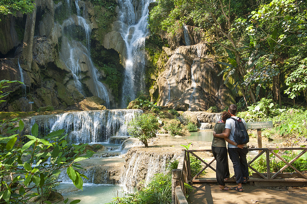 Couple admiring the Kuang Si waterfalls,nearby Luang Prabang, Laos, Southeast Asia