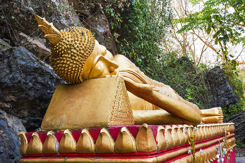 Lying Buddha statue on the path to the stupa of Wat Chom Si on the summit of Mount Phu Si, Luang Prabang, northern Laos, Southeast Asia