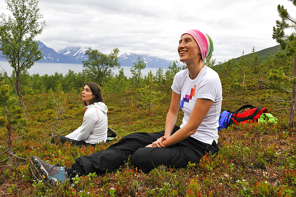 Young women having a rest, Nordmannvikdalen valley,region of Lyngen,County of Troms,Norway,Northern Europe