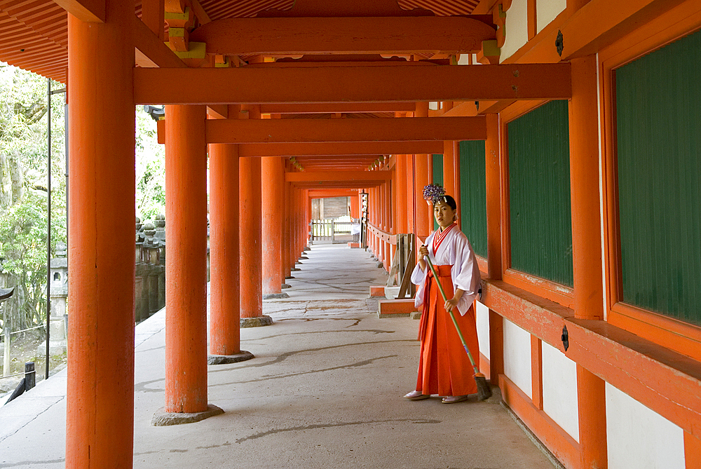 Miko or shrine maiden (Young women serving in a Shinto shrine) at Kasuga Taisha Shinto shrine, Nara, Japan