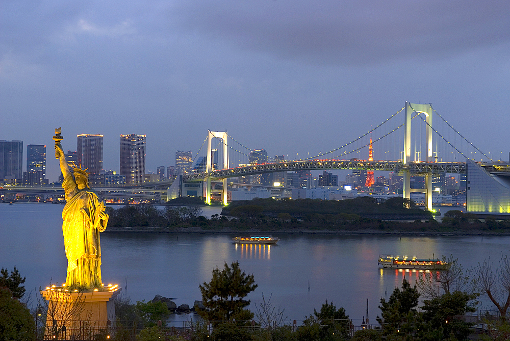 Rainbow Bridge, with in the foreground the replica of the Statue of Liberty, seen from Odaiba, a large artificial island in Tokyo Bay, Japan