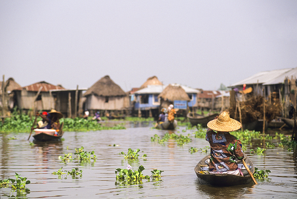 Villagers moving by pirogue on Ganvie lake village in Lake Nokoué, near Cotonou, Gulf of Guinea, West Africa