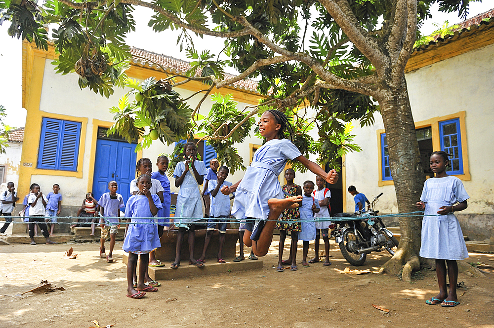 Pupils playing bungee jumping in the playground of the primary school in the village of Praia das Conchas, in the northern part of Sao Tome Island, Republic of Sao Tome and Principe,Africa