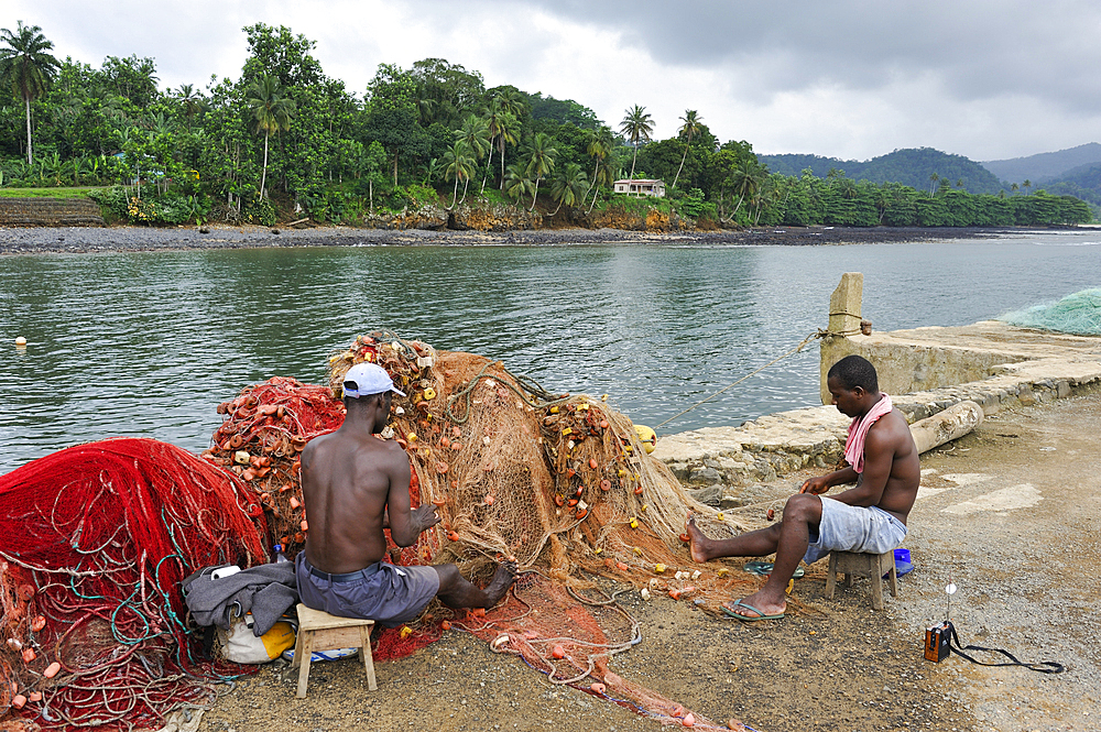 Men mending fishing net at Porto Alegre village in the south of Sao Tome Island, Republic of Sao Tome and Principe,Africa