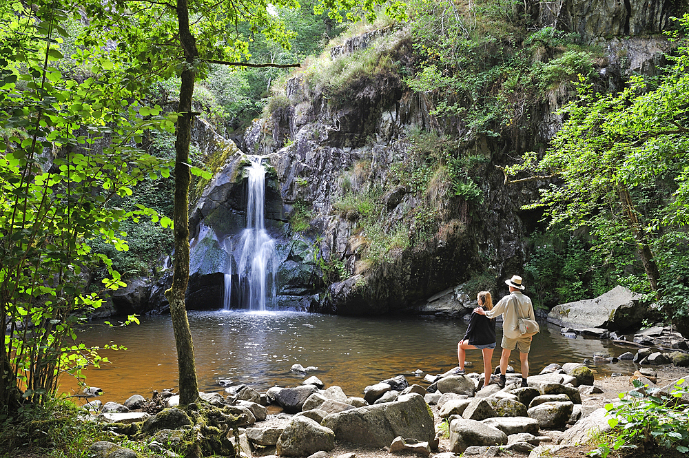 Father and his daughter admiring the waterfall of Gour Saillant fed by the Auzelle, a sub-tributary of the Sioule River, Saint-Priest-des-Champs, Puy-de-Dome department, Auvergne-Rhone-Alpes region, France, Europe