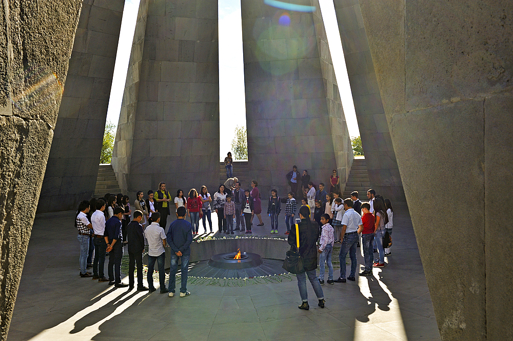 Moment of reverence in front of the eternal flame at the center of the twelve granite slabs of the Armenian Genocide memorial complex on the hill of Tsitsernakaberd at Yerevan, Armenia, Eurasia