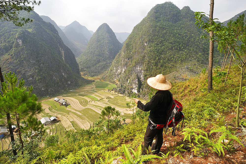Man watching the landscape in Sa Phyn valley, Dong Van Karst Plateau Geopark, near Dong Van, Ha Giang province, Northern Vietnam, Southeast Asia