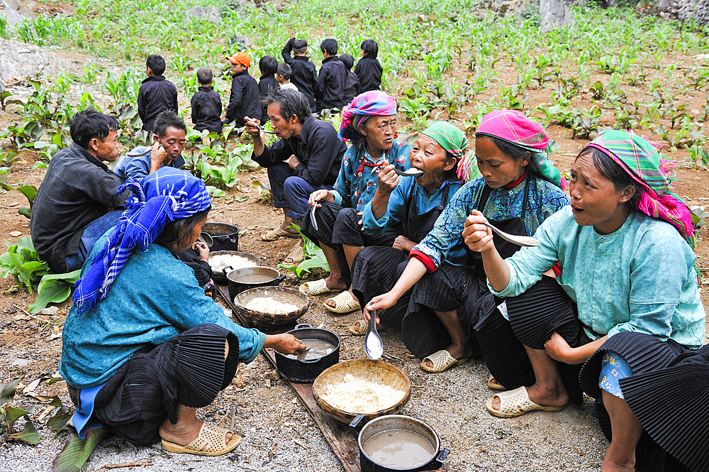 H'mong women and children taking communal lunch during funeral in a village around Sa Phin, Ha Giang province, Northern Vietnam, Southeast Asia