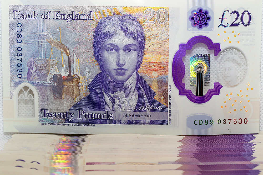 A close-up of a £20 British banknote featuring a portrait of a historical figure, with intricate security features and holograms visible.