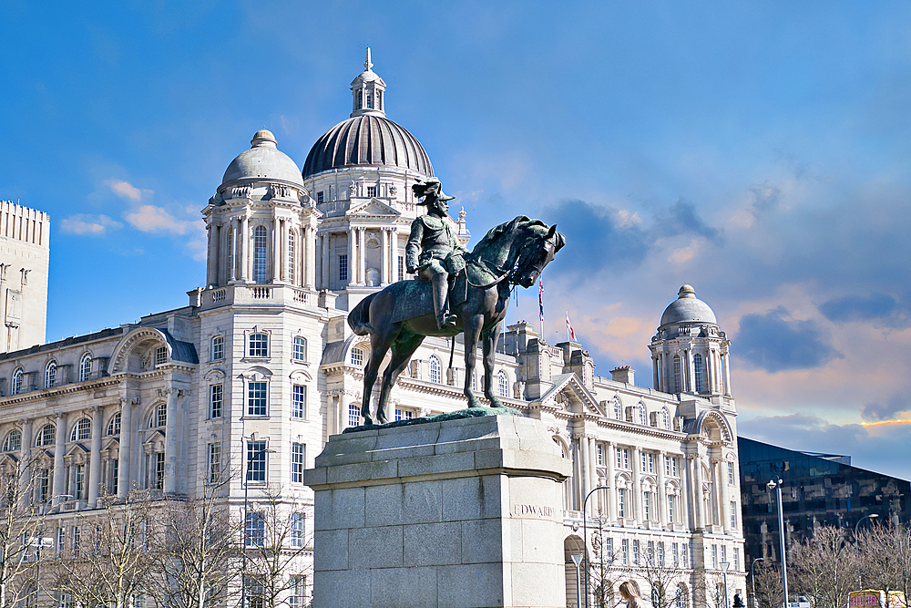 Equestrian statue of King Edward VII in front of the Royal Liver Building in Liverpool, under a partly cloudy sky in Liverpool, UK.