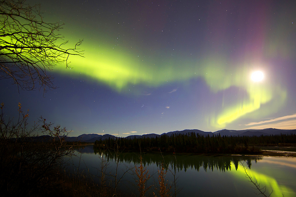 Aurora borealis and Full Moon over the Yukon River, with Pleiades, Whitehorse, Yukon, Canada.