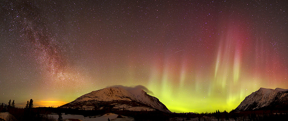 Red aurora borealis, shooting star, and Milky Way over Carcross Desert, Carcross, Yukon, Canada.