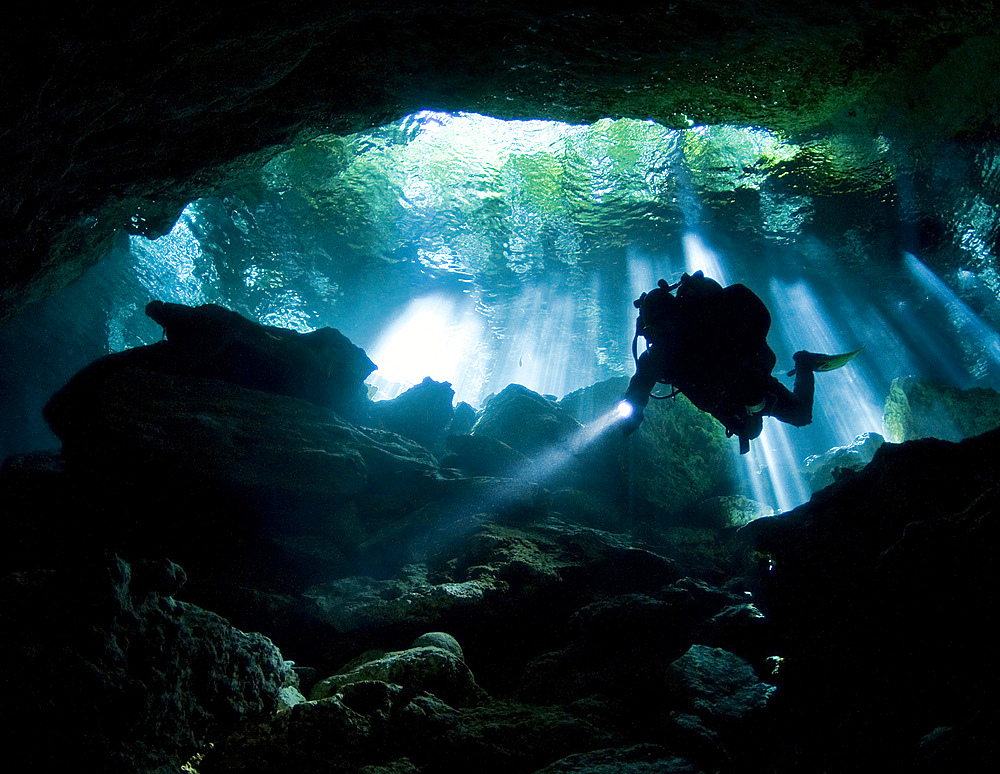 Cenote diver enters Taj mahal cavern on Yucatan peninsula in Mexico.