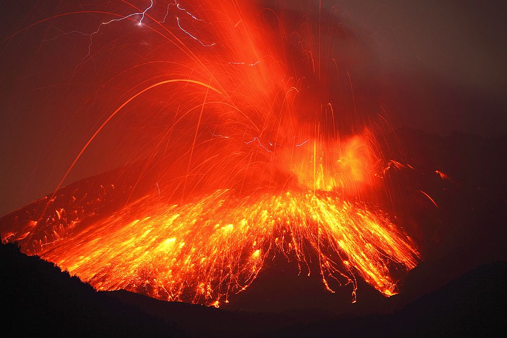 February 23, 2013 - Powerful night time explosive eruption of Sakurajima volcano, Japan. Trajectories of glowing incandescent volcanic bombs are visible. Static lightning discharges are visible at top of picture.
