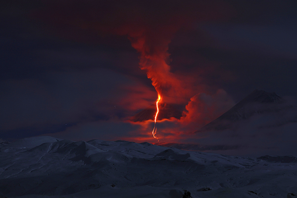 October 16, 2013 - Nighttime eruption of Kliuchevskoi (Klyuchevskoy) Volcano, Kamchatka, Russia. Ash cloud and lava flow are produced by the activity of the volcano which is partially shrouded in cloud. Kamen volcano is seen on right.