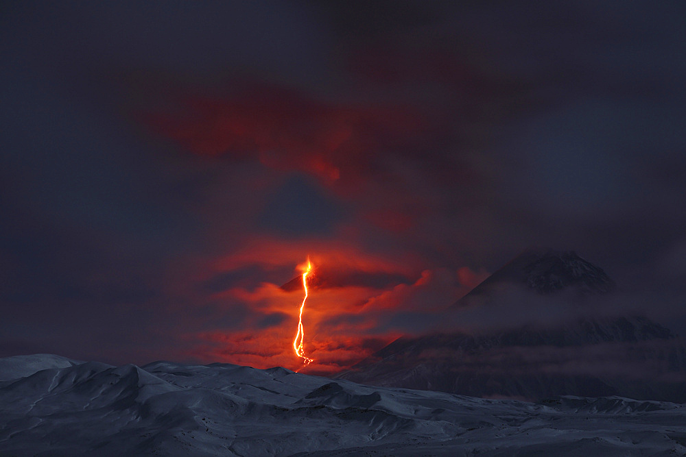 October 16, 2013 - Eruption of Kliuchevskoi (Klyuchevskoy) Volcano, Kamchatka, Russia. Ash cloud and lava flow are produced by the volcano which is partially shrouded in cloud. Kamen volcano is seen on right.