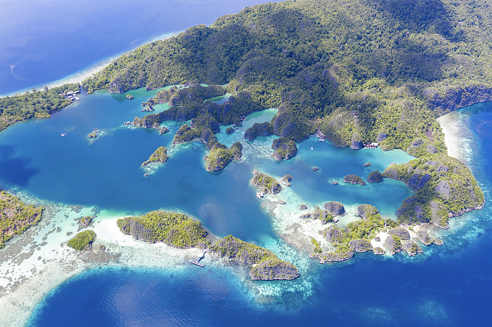 Rugged and remote, limestone islands rise around a beautiful lagoon seascape in Raja Ampat, Indonesia. This region is known as the heart of the Coral Triangle due to its incredible marine biodiversity. It is a popular destination for scuba divers and snor