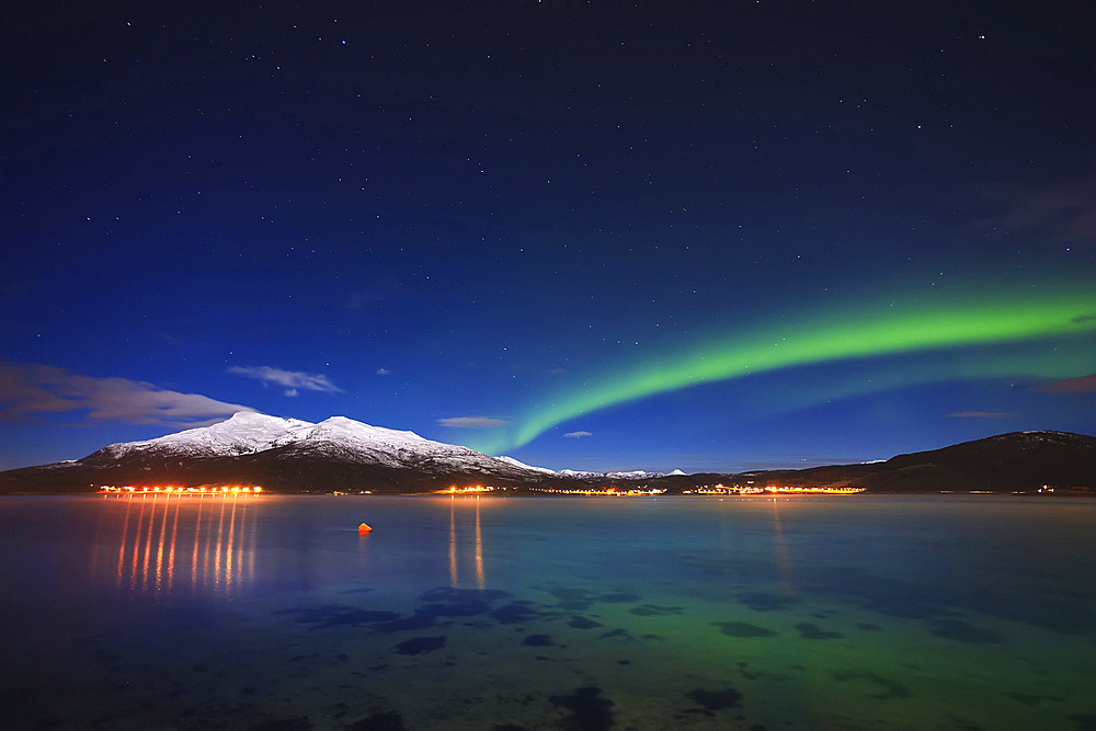 Aurora over Tjeldsundet and Saetertinden Mountain in Troms County, Norway. Auroras are the result of the emissions of photons in the Earth's upper atmosphere.