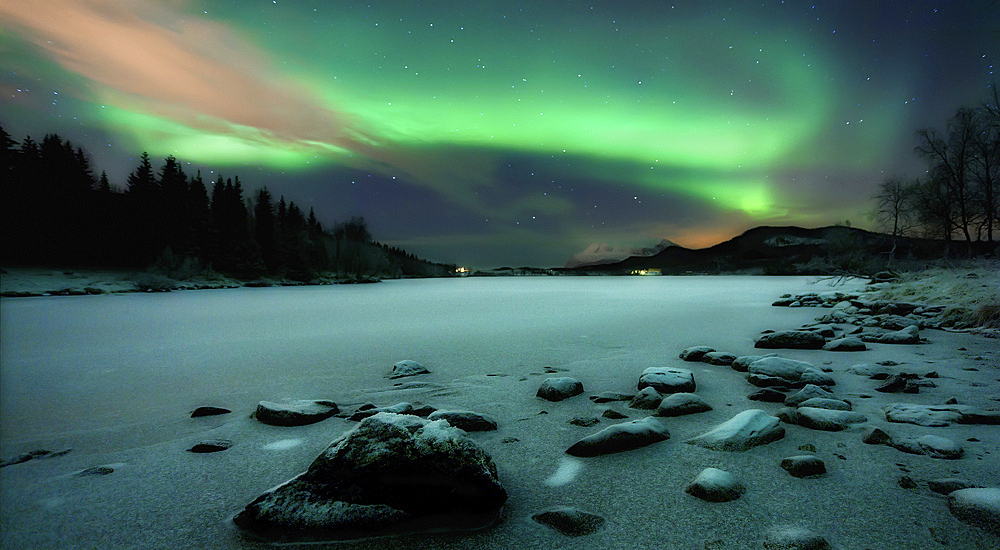 Aurora Borealis over Sandvannet Lake in Troms County, Norway. Auroras are the result of the emissions of photons in the Earth's upper atmosphere.