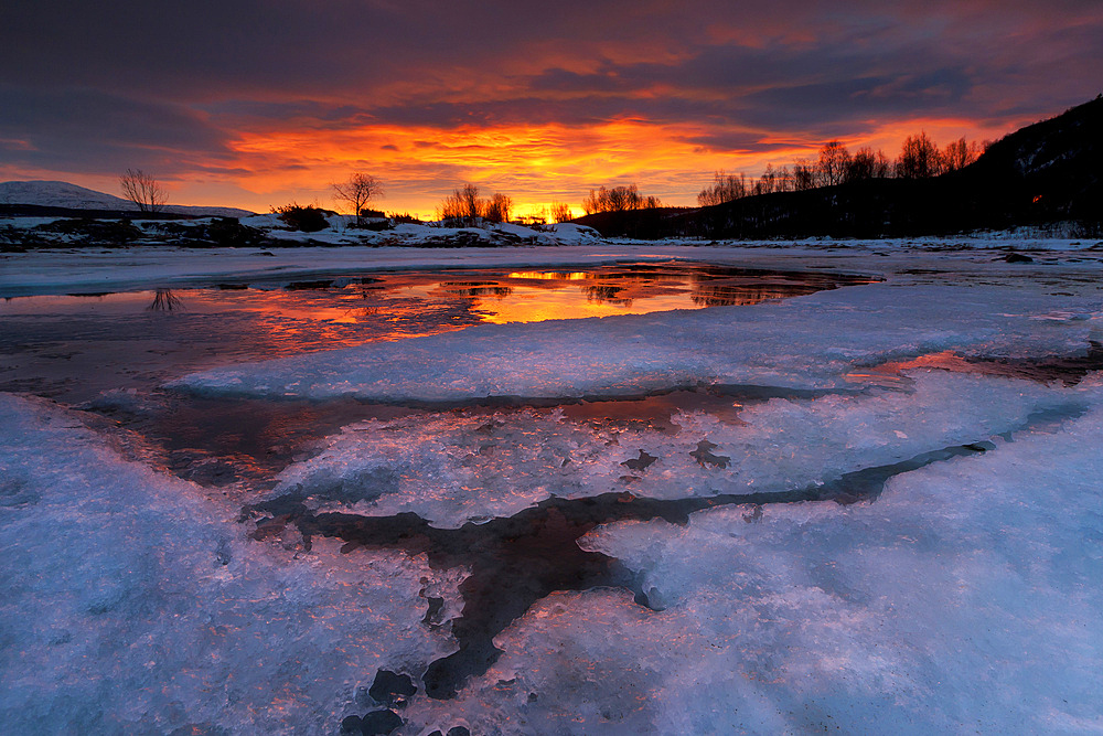 A fiery sunrise over Lavangsfjord, Troms, Norway.