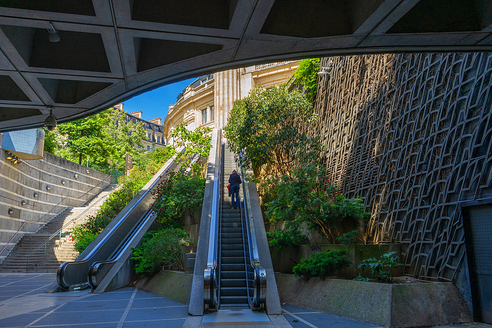 Passenger ascending on escalator from Les Halles to the Bourse on clear summer day