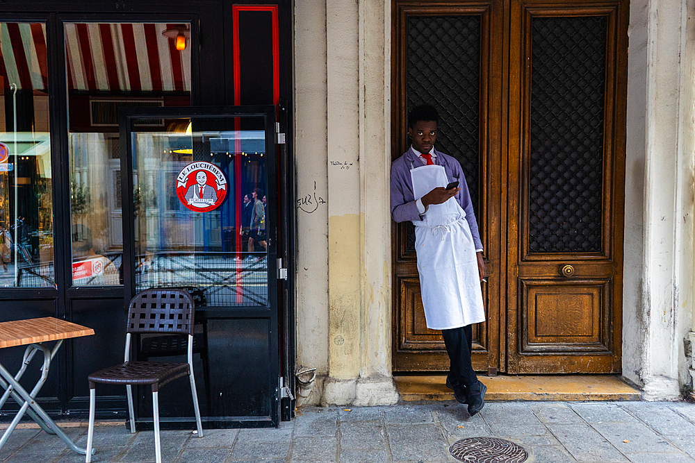 Waiter on a break outside a restaurant in Paris