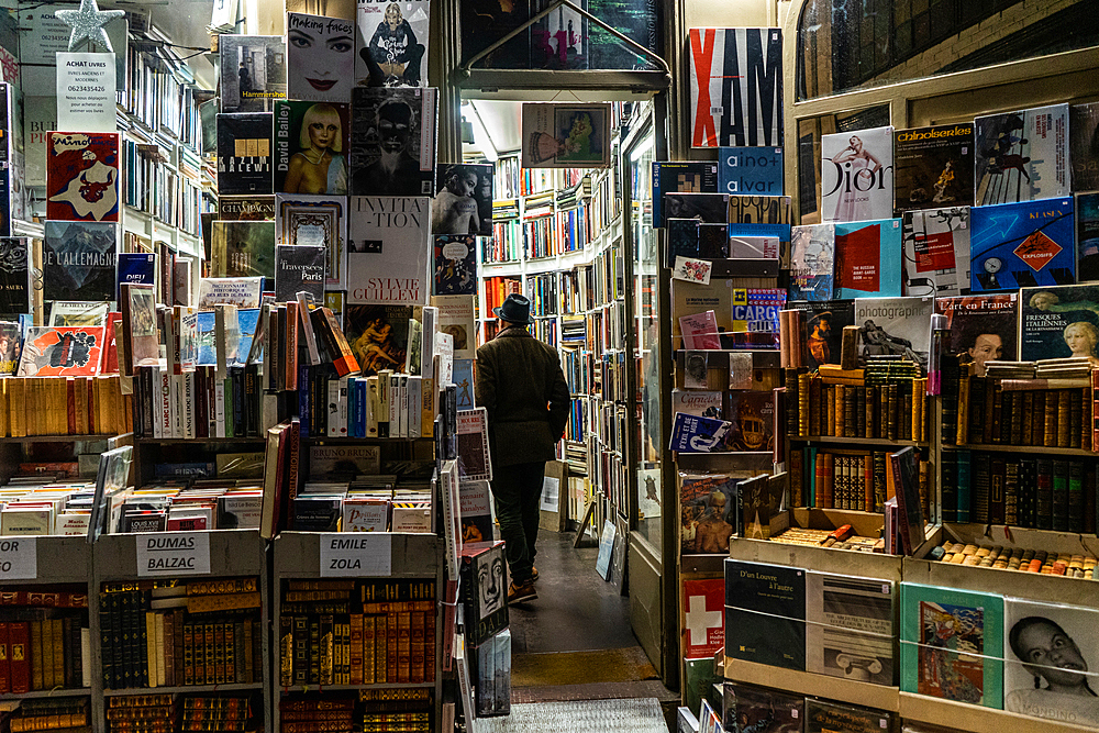 Man in hat enters bookshop in Passage Jouffroy, Paris, France