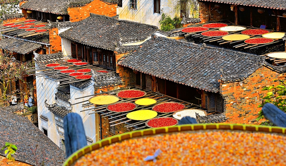 Chillies, corn and other produce being sun dried in autumn, Huangling, Wuyuan County, Shangrao City, Jiangxi Province, China. Huangling is an ancient village that dates back to the Ming Dynasty more than 500 years ago and is known for its natural beauty.