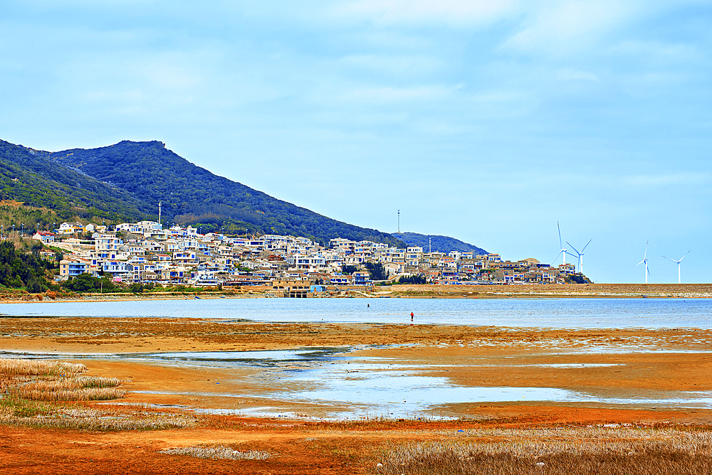 Village by the sea with an accompaniment of windmills. Pingtan Island, Fuzhou City, Fujian Province, China.