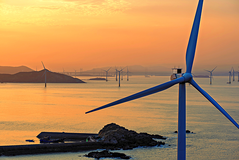 Windmills in a golden sunset. Pingtan Island, Fuzhou City, Fujian Province, China.