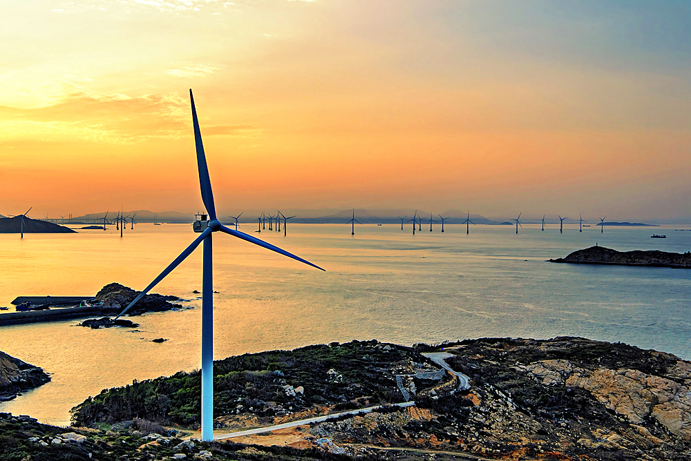 Windmills in a golden sunset. Pingtan Island, Fuzhou City, Fujian Province, China.