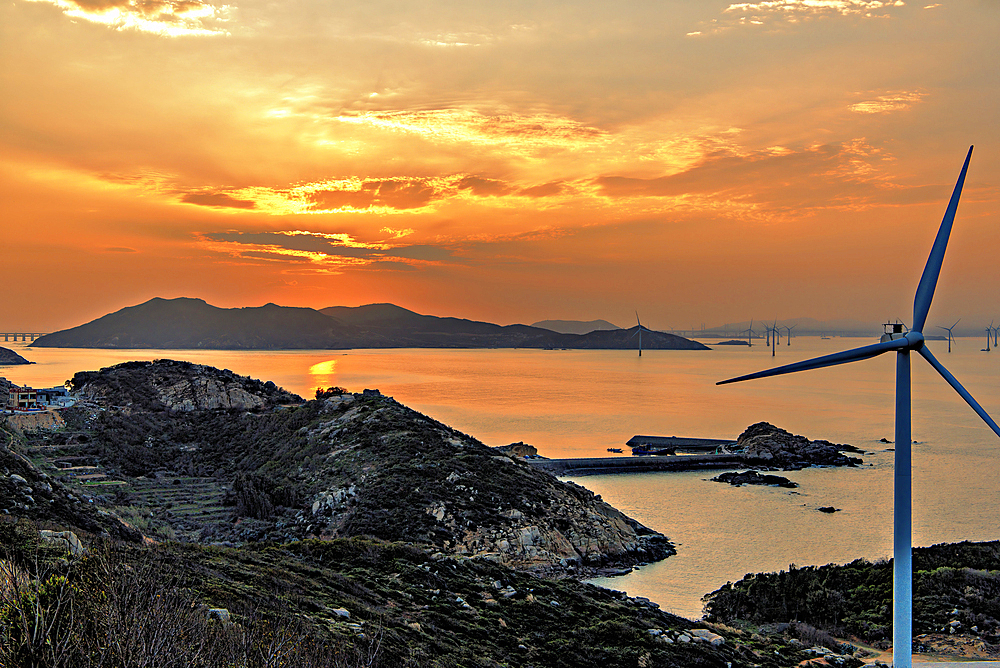 Windmills in a golden sunset. Pingtan Island, Fuzhou City, Fujian Province, China.