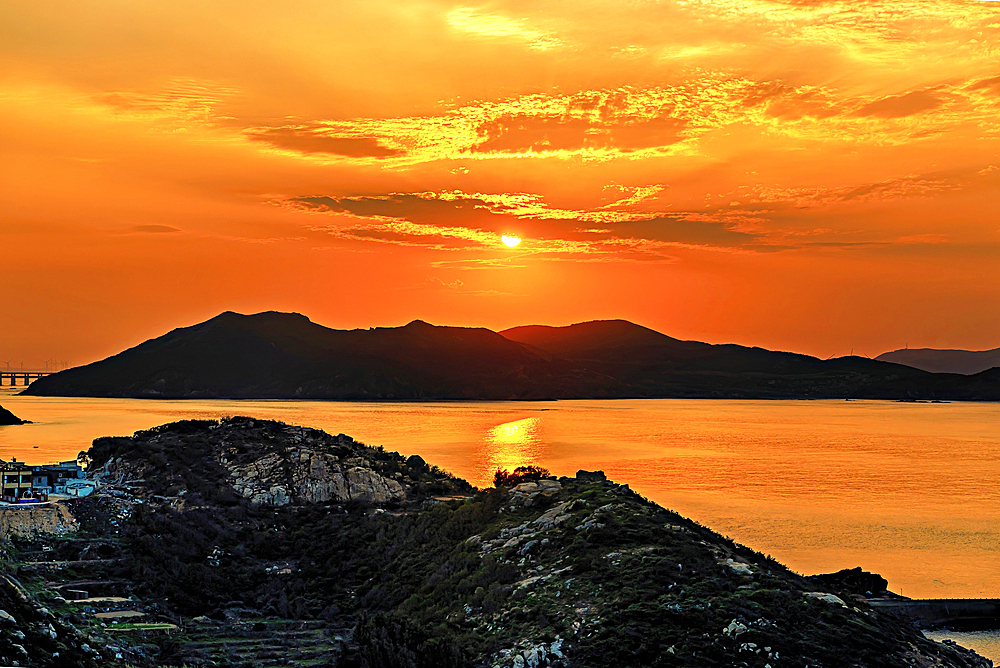 Golden sunset over the hills and the sea of Pingtan Island, Fuzhou City, Fujian Province, China.