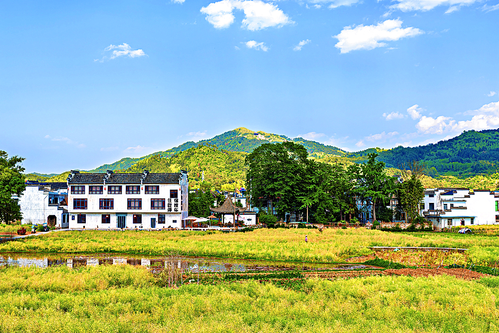 View of new buildings and farms beside Chengkan Ancient Village, Huangshan City, Anhui, China. Chengkan Ancient Village was established 1800 years ago by the Luo family clan. It has buildings dating as early as the Song Dynasty (960 to 1279 AD).
