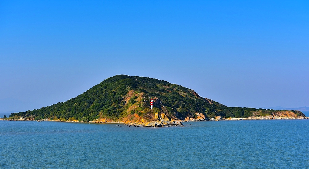 Striking lighthouse in red and white on Fengyu Islet off Nan'ao Island, Shantou City, Guangdong Province, China. Nan'ao Island is a resort island of Shantou City.