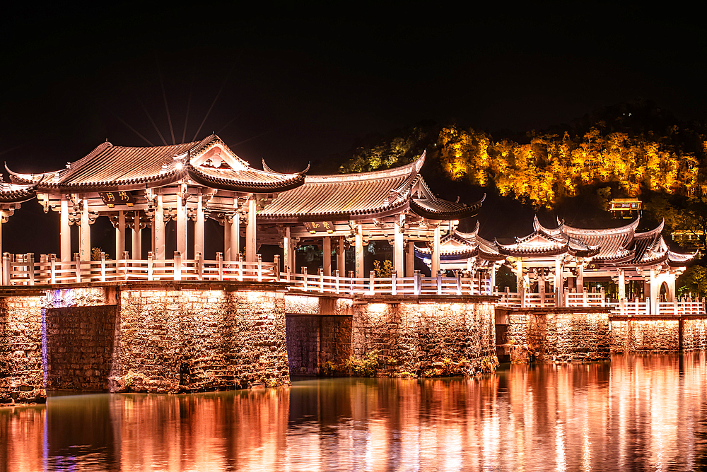 Guangji Bridge at night. Built in 1170, it is one of China's four famous ancient bridges. Chaozhou, Guangdong province, China. The bridge is connected by 18 boats that can be moved to allow passage for vessels. The bridge is disconnect at night.