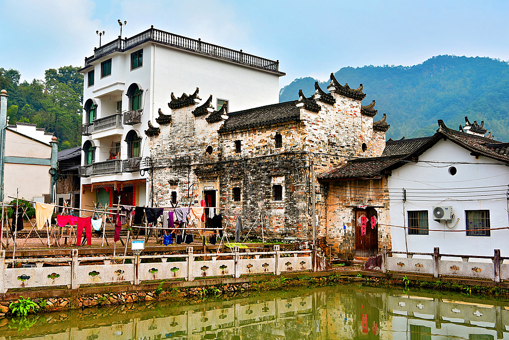 Newer and ancient houses in picturesque Guodong Ancient Village, Wuyi County, Jinhua City, Zhejiang Province, China. The 1000 year old village is still well inhabit with ancient buildings as early as the Wanli period (1573-1620) during the Ming Dynasty.