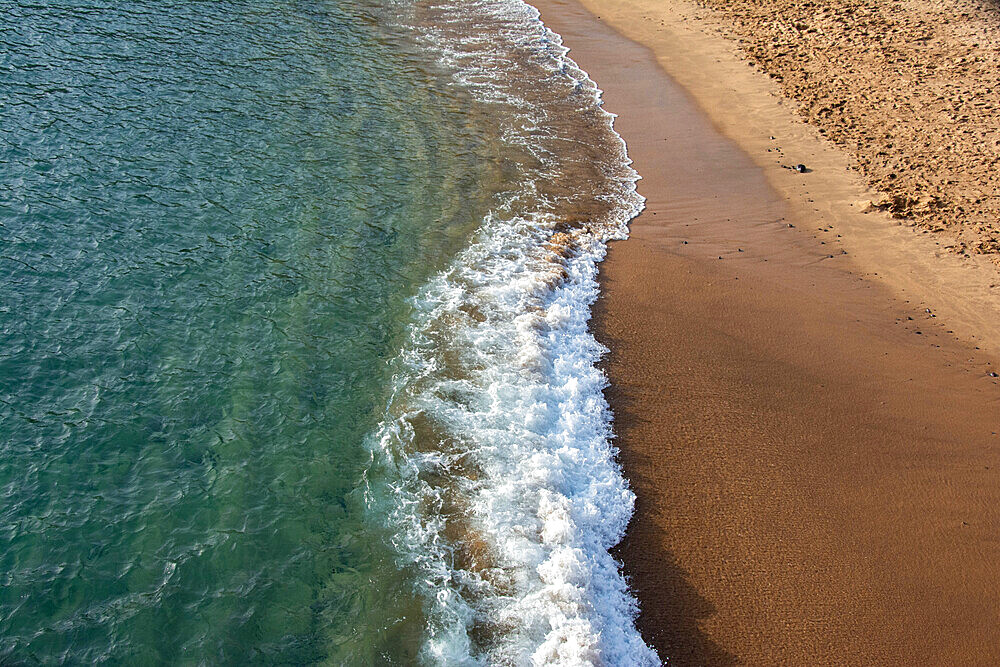 Aerial Drone shot showing the wave breaks on the golden coloured sand beach