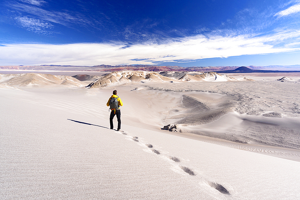 Tourist walking on white dunes, Campo de Piedra Pomez, El Penon, Puna, Catamarca, Argentina. (MR)